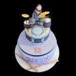 Torta decorata in pasta di zucchero per un compleanno a tema batteria