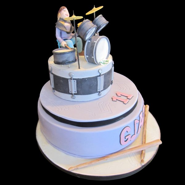 Torta decorata in pasta di zucchero per un compleanno a tema batteria