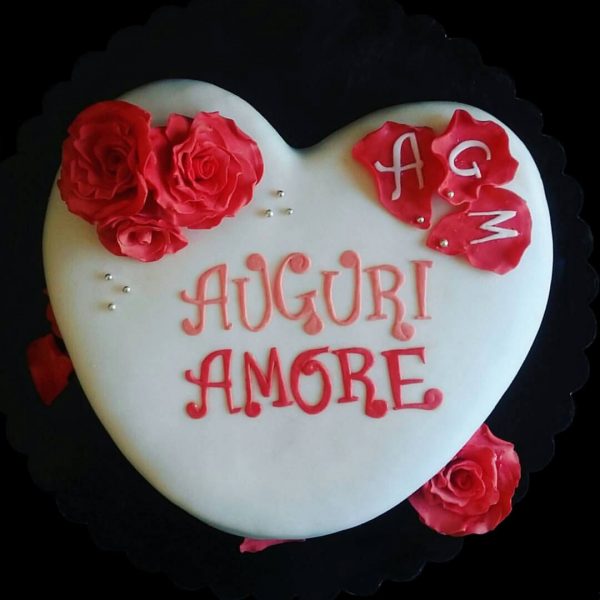 Torta a forma di cuore decorata con rose rosse in pasta di zucchero per un compleanno